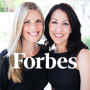 Laurie and Erin behind Forbes logo